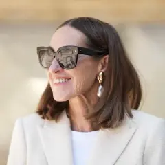 Stilvolle Frau mit mittellangem Haar, Sonnenbrille und auffälligem Ohrring. Perfekt für unkomplizierte Frisuren mittellang ab 50.