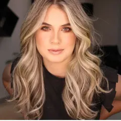 Blonde Frau mit welligem Haar, das ihr Gesicht umrahmt.