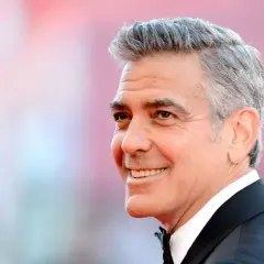 George Clooney zeigt eine stilvolle Frisur für Herren ab 60 Jahren, mit grauem Haar und einem charmanten Lächeln.