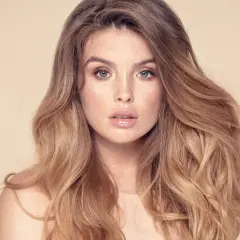 Frau mit vollem, welligem Haar und Sommersprossen. Sie träumt davon, dickere Haare zu bekommen, um diesen Look zu erzielen.