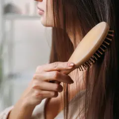 Frau kämmt ihr langes Haar. Sie hofft, dass dies gegen ihren extremen Haarausfall hilft.