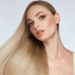 Blondes Haar, das glänzt und fällt, zeigt, wie man die Haarstruktur verbessern kann.