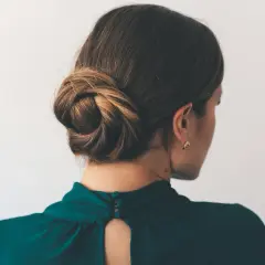 Eine Frau mit einem eleganten Dutt, der ihr Haar kunstvoll zusammenhält.