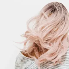 Eine Person mit langen, welligen, rosafarbenen Haaren. Die Haarfarben mischen Tabelle könnte hier inspirieren.