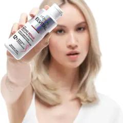 Frau hält L'Oréal Elvital Bond Repair Pre-Shampoo, um trockene Haare zu retten.