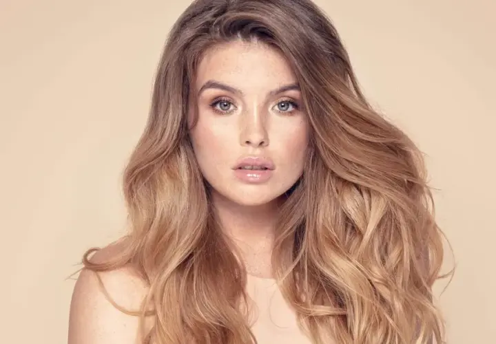 Frau mit vollem, welligem Haar und Sommersprossen. Sie träumt davon, dickere Haare zu bekommen, um diesen Look zu erzielen.