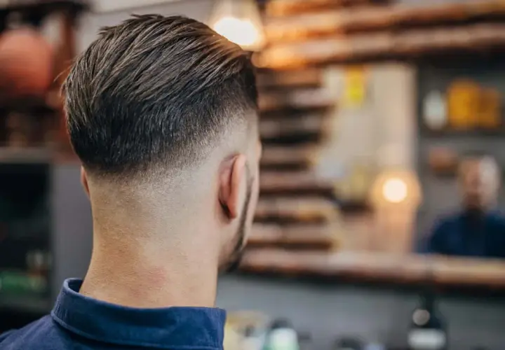 Mann mit modernem Fade-Haarschnitt, eine der angesagten herren frisuren. Der Übergang von kurz zu lang ist perfekt.