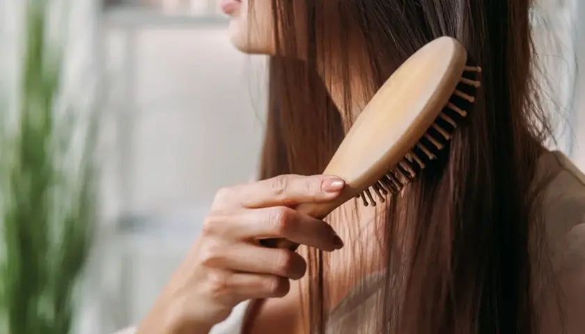 Frau kämmt ihr langes Haar. Sie hofft, dass dies gegen ihren extremen Haarausfall hilft.