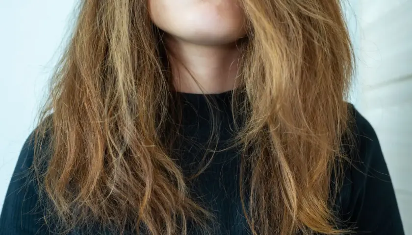 Frau mit strohigem Haar, das nach einer pre shampoo Behandlung schreit.