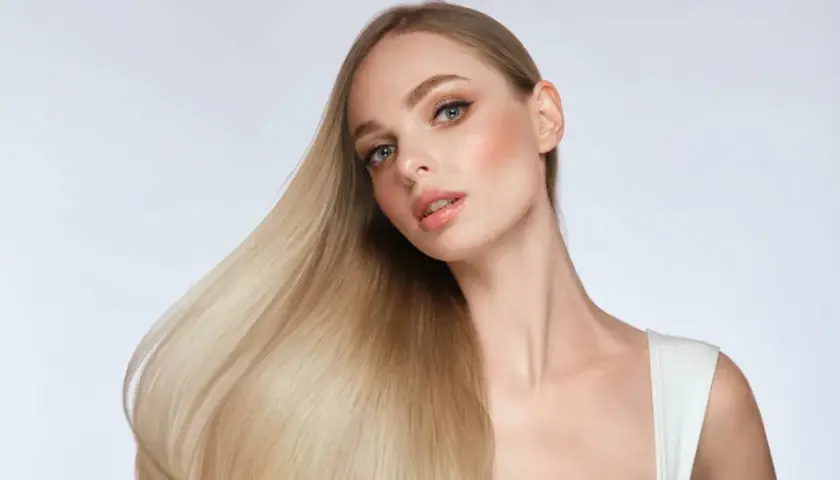 Blondes Haar, das glänzt und fällt, zeigt, wie man die Haarstruktur verbessern kann.