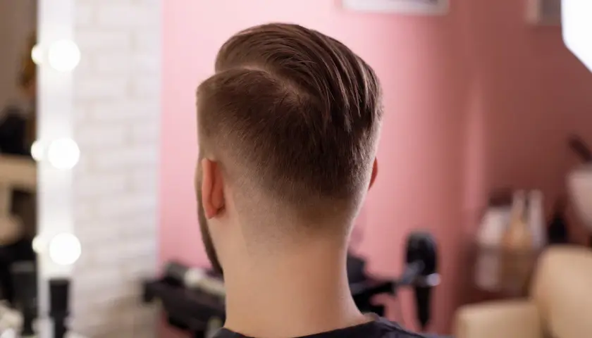 Mann mit einem modernen Mid Fade French Crop Haarschnitt, der die Seiten sanft ausblendet.