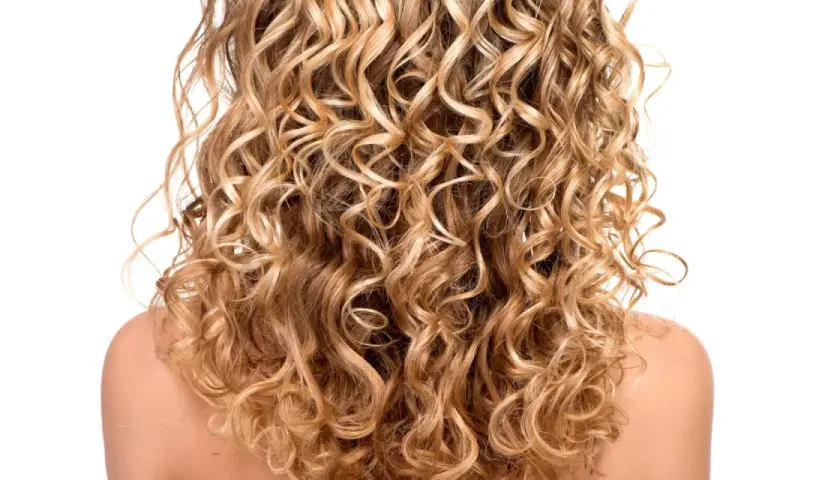 Ein Rücken mit vollem, blondem, krausem Haar, das in perfekten Locken fällt.
