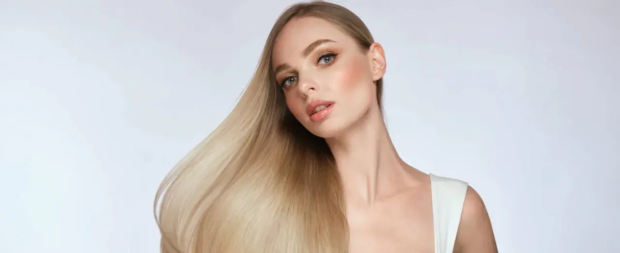 Blondes Haar, das glänzt und fällt, zeigt, wie man die Haarstruktur verbessern kann.