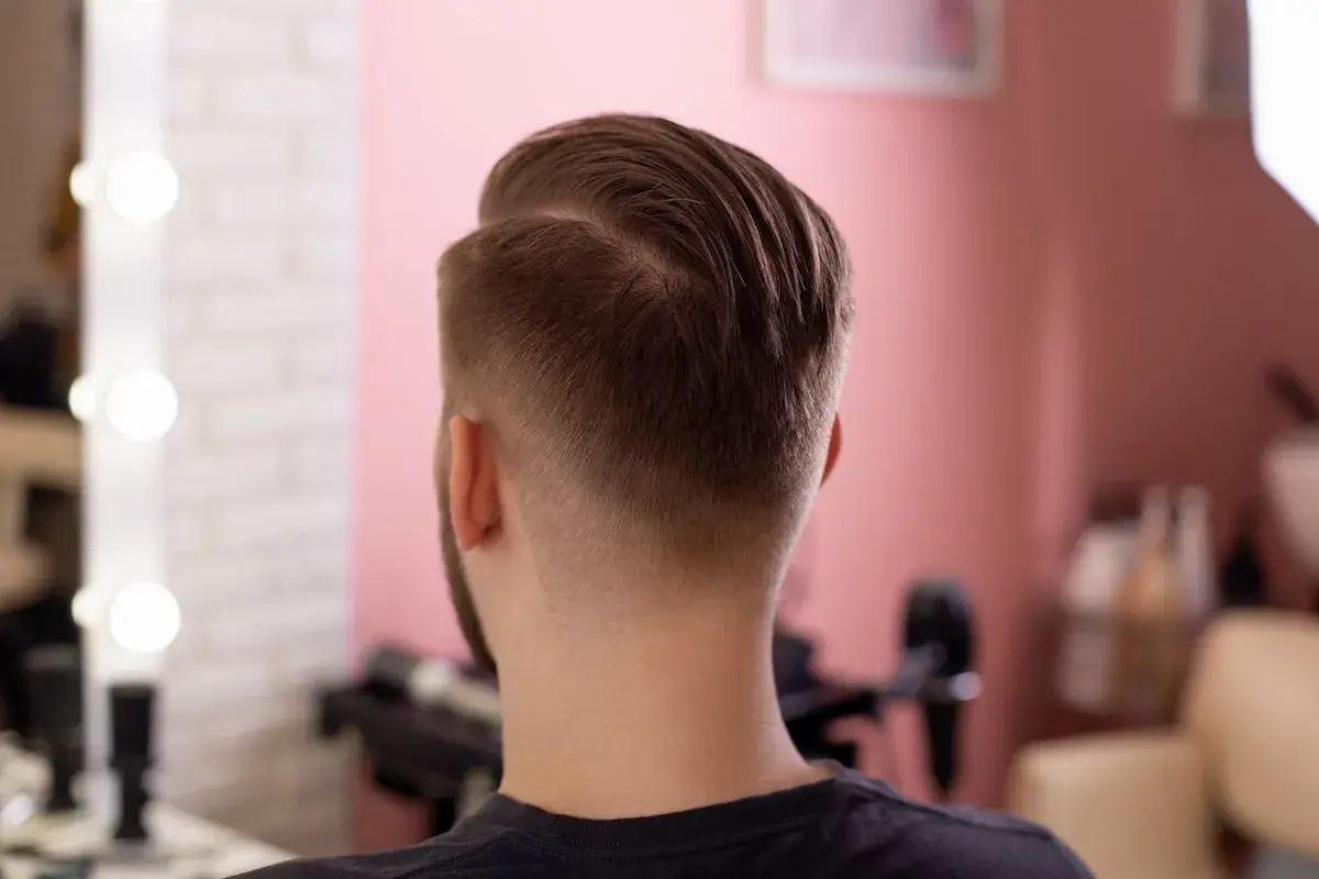 Mann mit einem modernen Mid Fade French Crop Haarschnitt, der die Seiten sanft ausblendet.