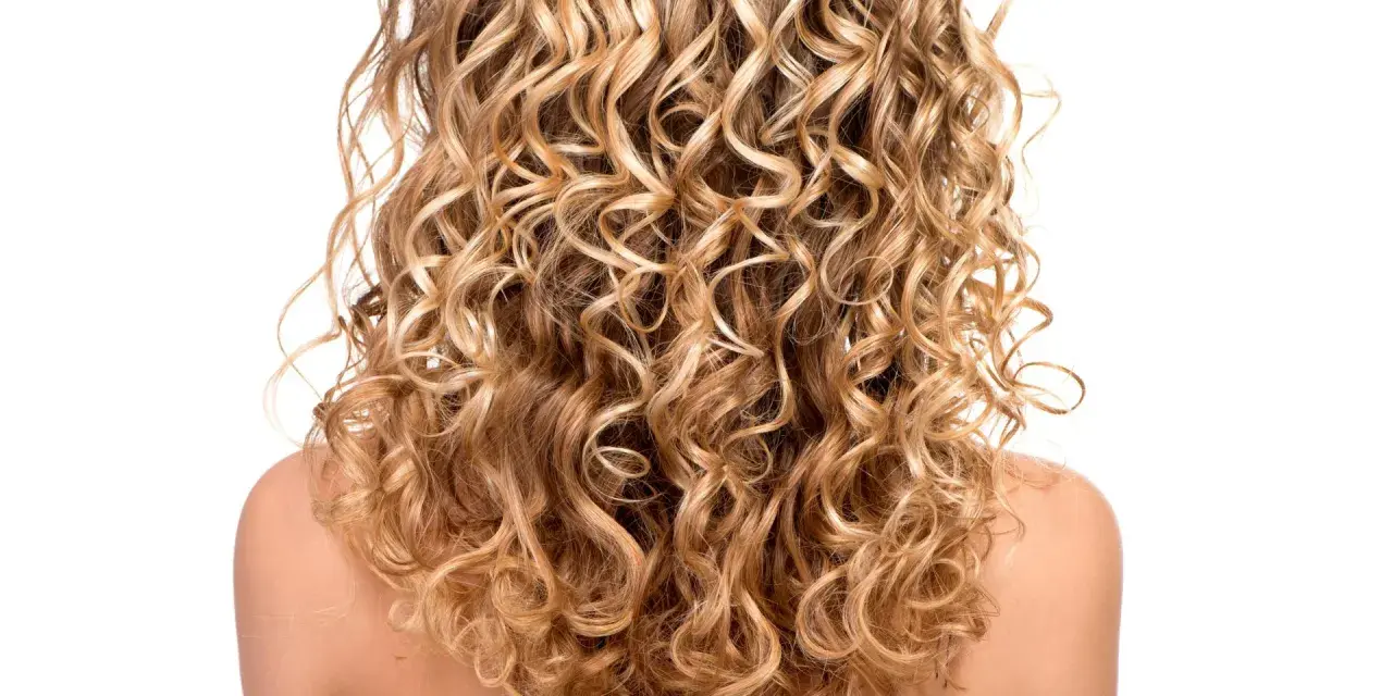 Ein Rücken mit vollem, blondem, krausem Haar, das in perfekten Locken fällt.