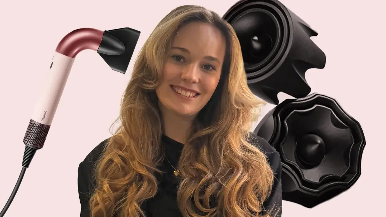 Lächelnde Frau mit voluminösen, welligen Haaren, die durch einen Dyson-Haartrockner und schwarze Aufsätze betont werden. Die Konturen der Haare sind perfekt gestylt.