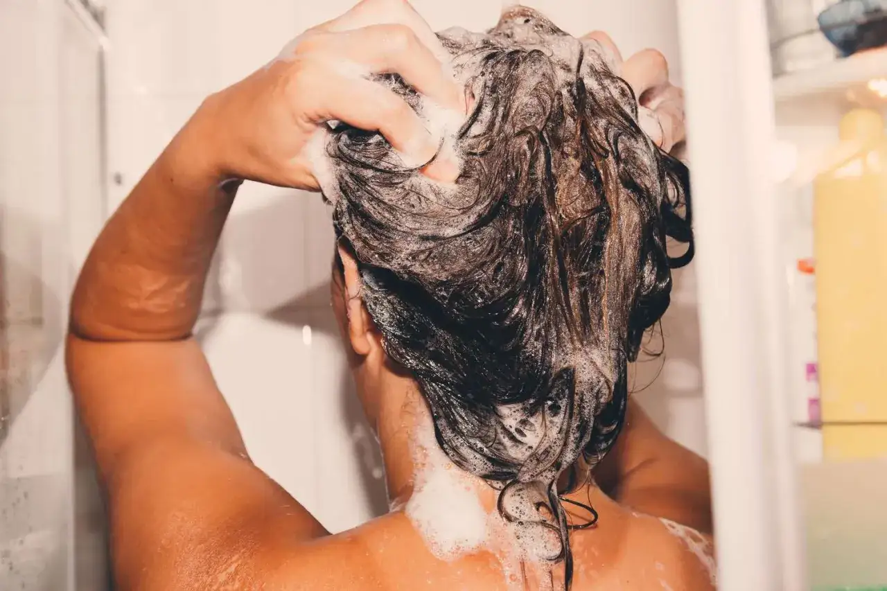 H&auml;nde massieren Schaum ins nasse Haar. Ein entspannender Moment beim Haare waschen.