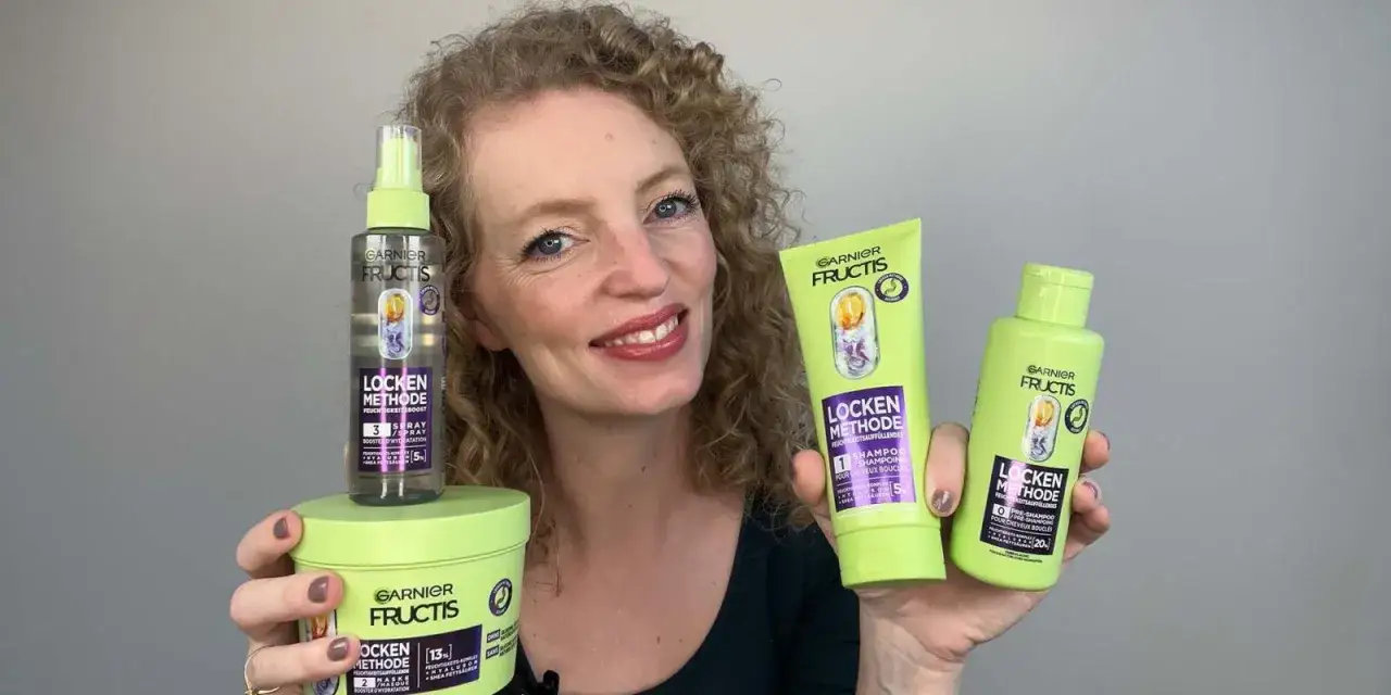 Frau mit lockigem Haar präsentiert die Garnier Fructis Locken Methode Produkte: Shampoo, Pre-Shampoo und Feuchtigkeits-Spray für definierte Locken.