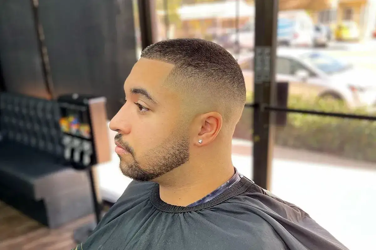 Mann mit Buzz Cut Taper Fade und Bart.