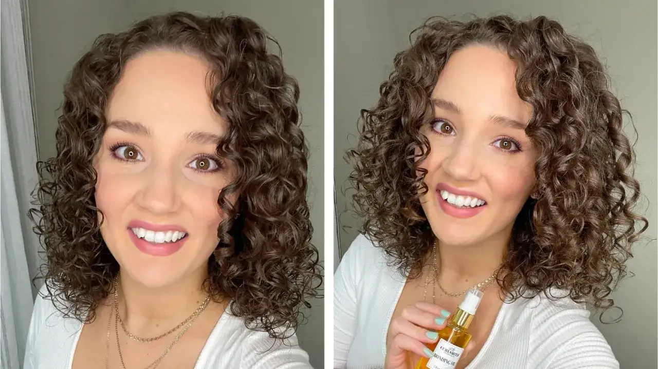 Frau mit vollen, definierten Locken, die ein Fläschchen Haaröl hält.