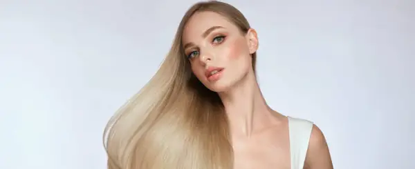 Blondes Haar, das glänzt und fällt, zeigt, wie man die Haarstruktur verbessern kann.